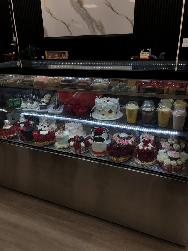The display case full of small cakes and dessert cups